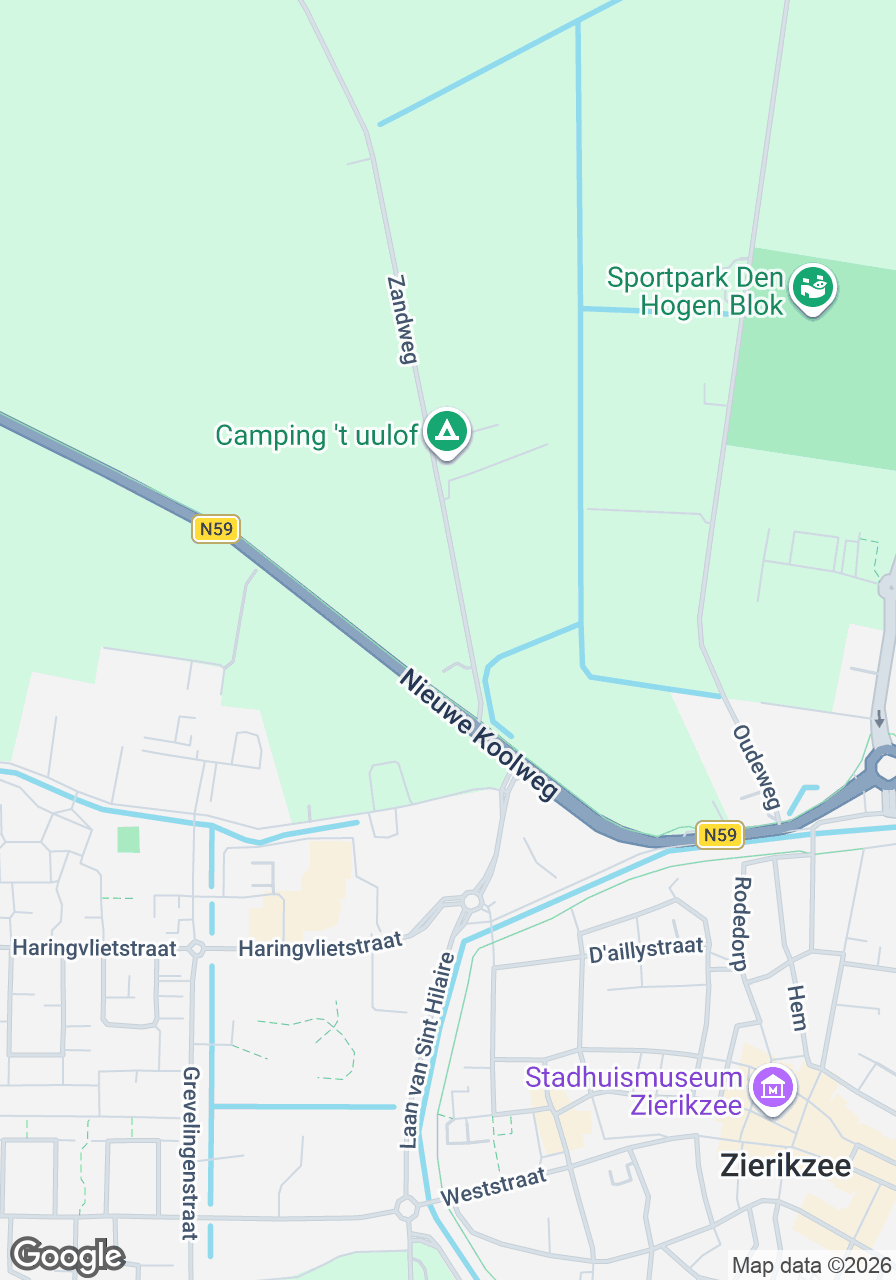 Gezicht op de Dorcas Winkel in Zierikzee, gelegen aan de Nieuwe Koolweg, met nabijgelegen winkels en groene omgeving.