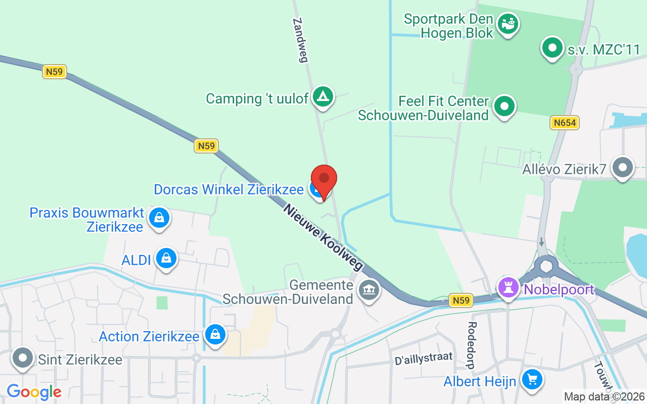 Gezicht op de Dorcas Winkel in Zierikzee, gelegen aan de Nieuwe Koolweg, met nabijgelegen winkels en groene omgeving.
