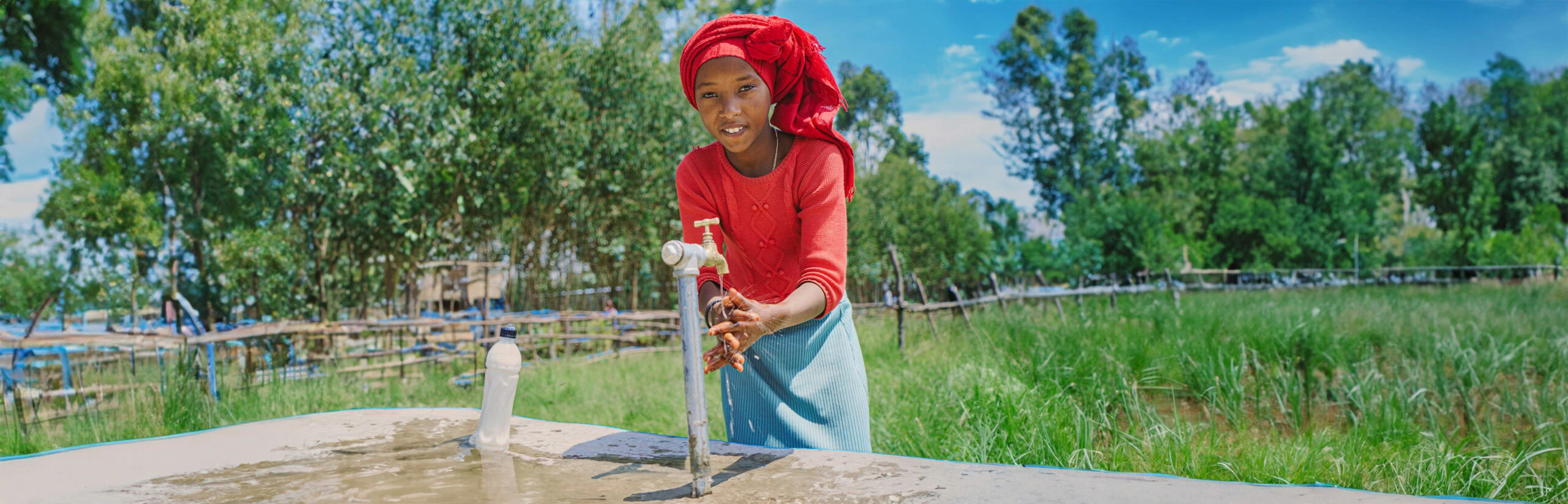 Geef voor water. Actie Waterkracht. Afbeelding meisje met water uit kraan in Ethiopië.