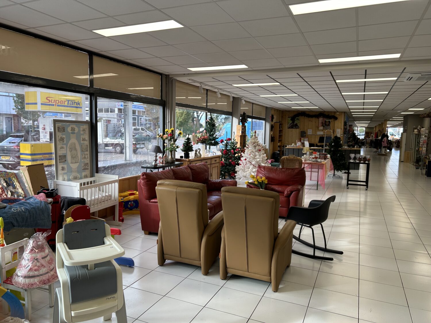 Leuk ingerichte winkelruimte met kerstversiering, zitplaatsen en diverse tweedehands spullen.