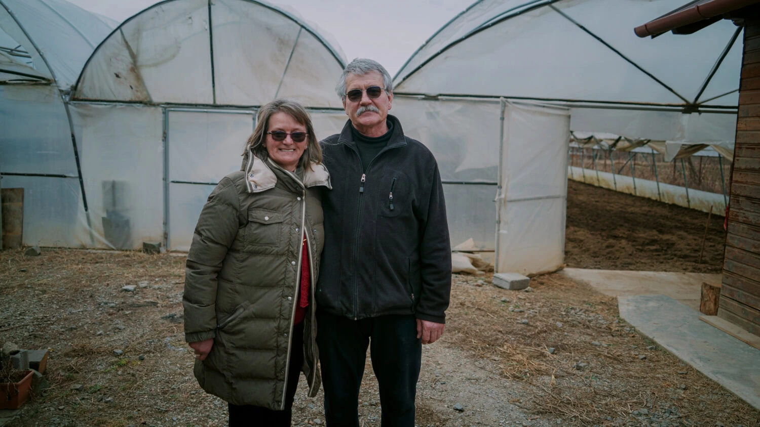 Twee mensen staan in een kas, geschikt voor kwetsbare groepen om voedsel te verbouwen, bij dorcas.nl.