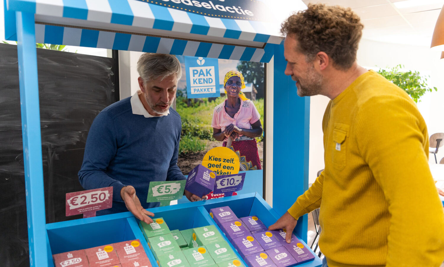 Dames en heren kopen gezonde producten bij een steunt Kiosk voor ontwikkelingshulp.
