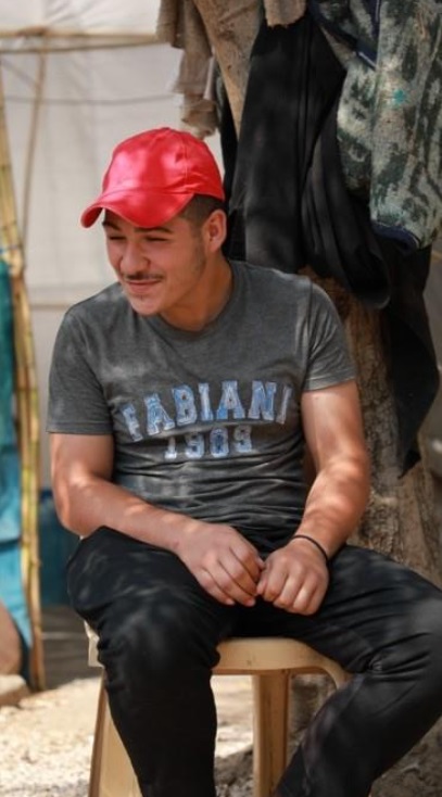 Broer Jawad: Man met rode cap en grijs T-shirt, lachend 