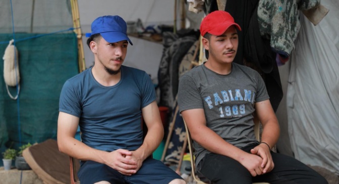 Twee jonge broers zitten samen in een tent, 