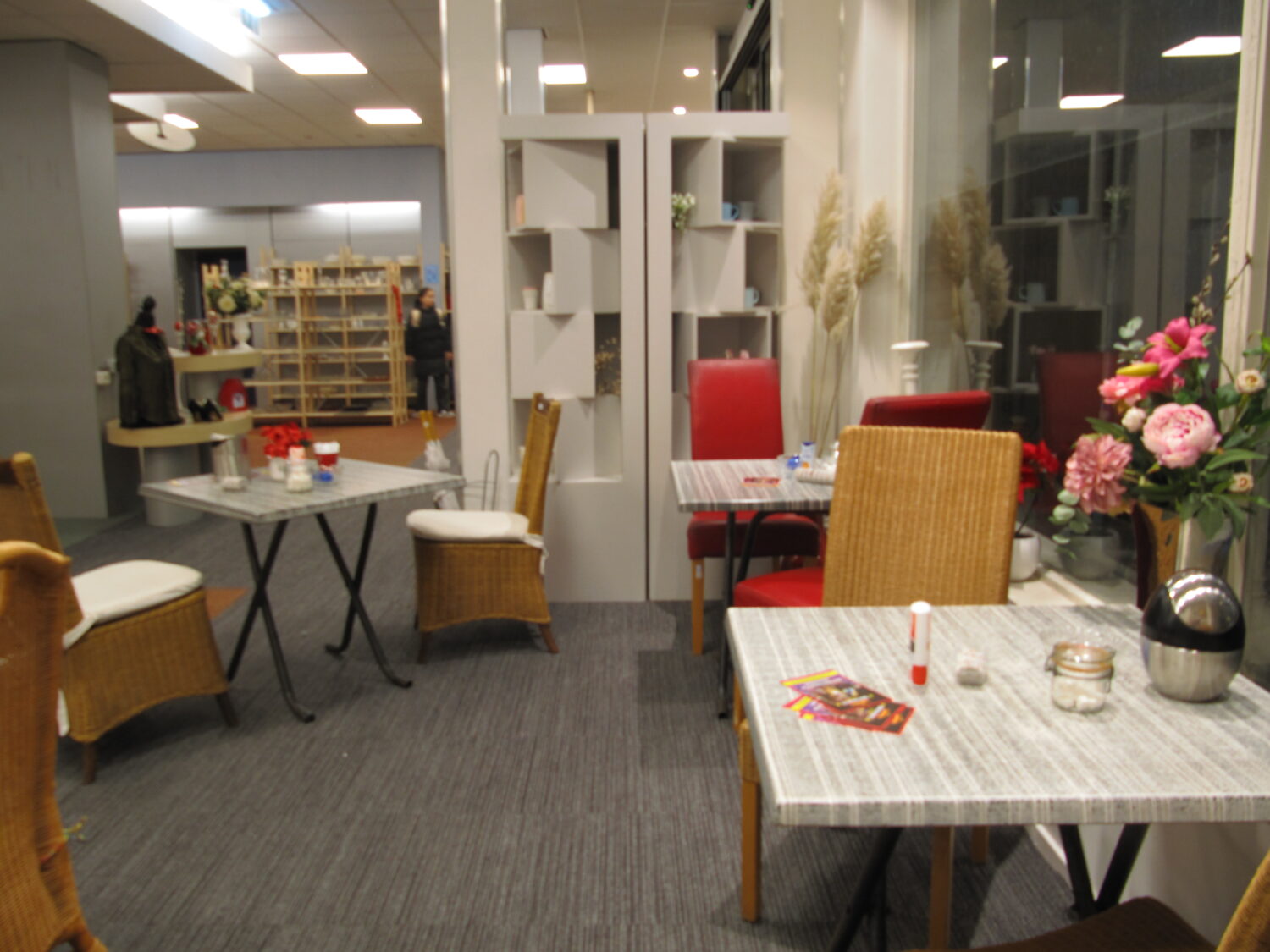 Warm betragten zithoeken in een gezellige winkel of caféomgeving met diverse meubels en decoraties.
