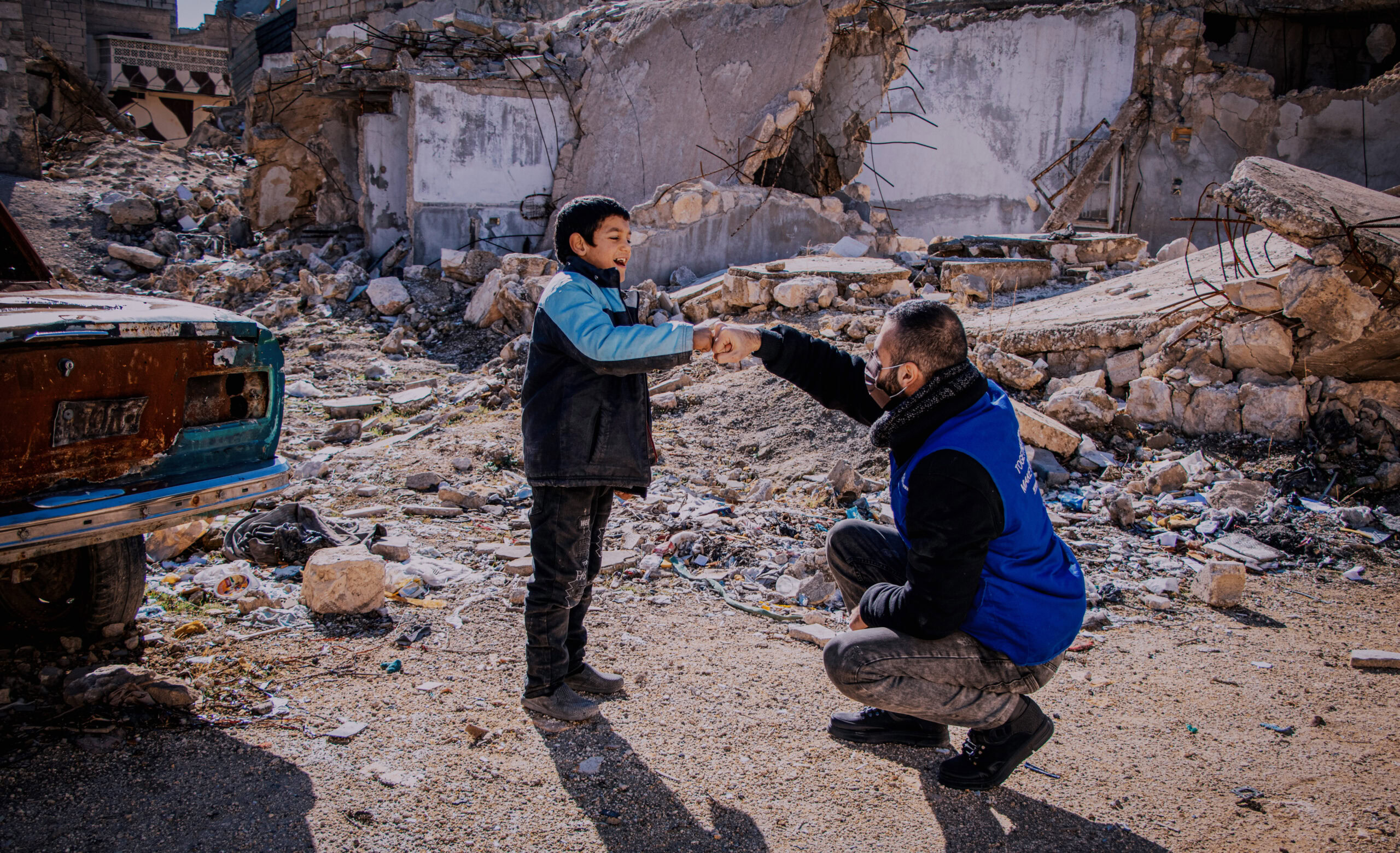 Helpende in humanitaire situatie aardbevingsgebied, kinderhelp en steun, liefdadigheidswerk door Dorcas, humanitaire hulp, reddingsactie, solidariteit en hoop voor getroffenen.