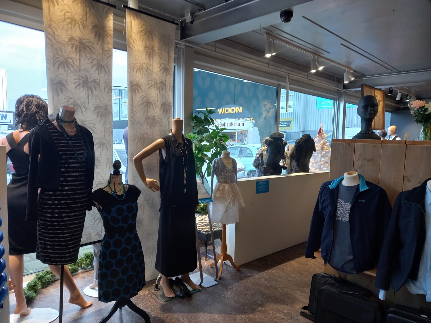 Drogaspresentatie met diverse mannequins en kleding in een winkel voor damesmode, met grote ramen en natuurlijke lichtinval.
