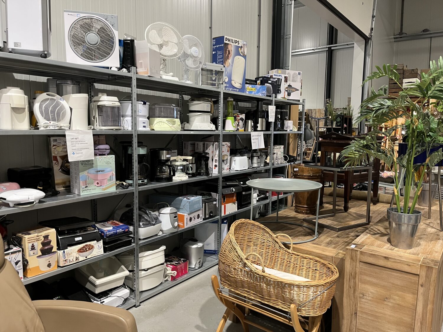 Veel gebruikte huishoudapparaten op de winkelvloer van Dorcas in een retailopstelling.
