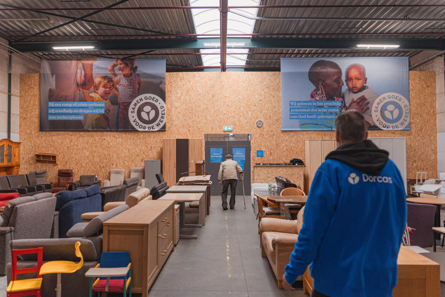 Hulpverleners in een donatiecentrum van Dorcas sorteren meubelen en textiel voor hulp aan slachtoffers van crisis en armoede.