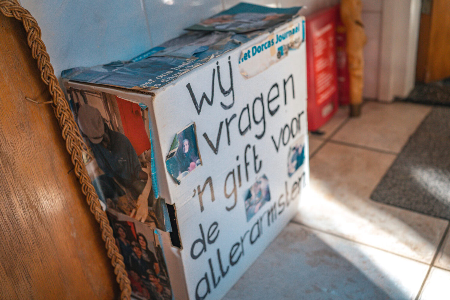 Versierde donatiebox met foto’s en tekst voor het inzamelen van gift voor de allerkleinsten bij Dorcas Nederland.