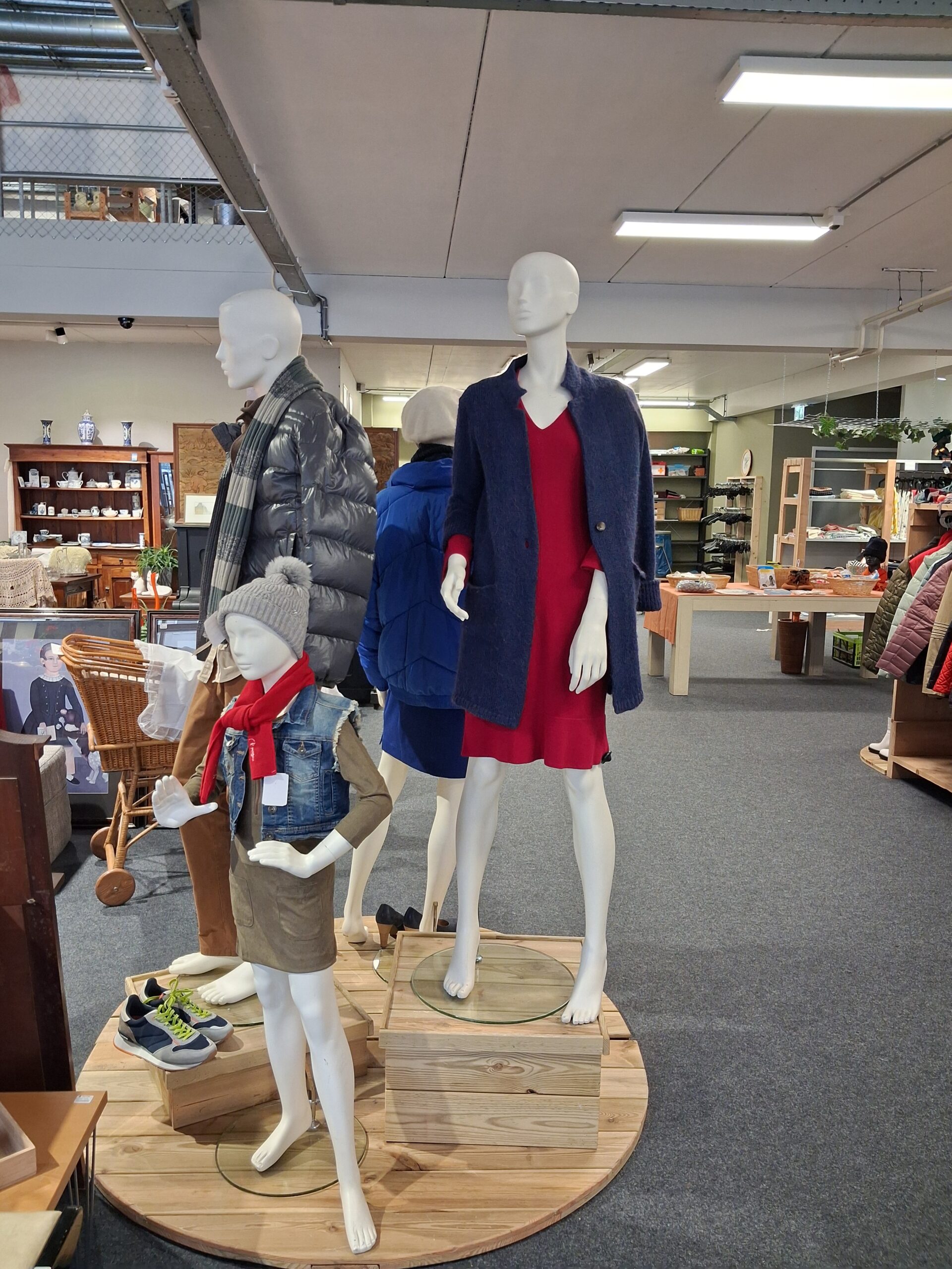 Dames en kinder mannequins getoond in een winkel met tweedehands kleding.