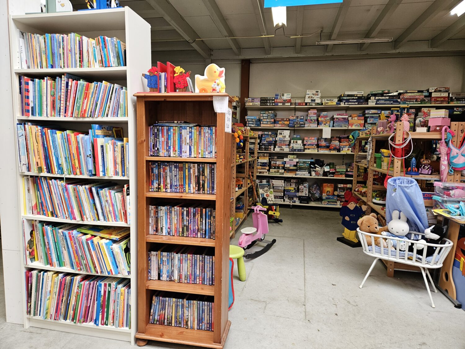Een overzicht van boeken en speelgoed voor kinderen in een winkel met diverse kinderproducten en speelmateriaal.