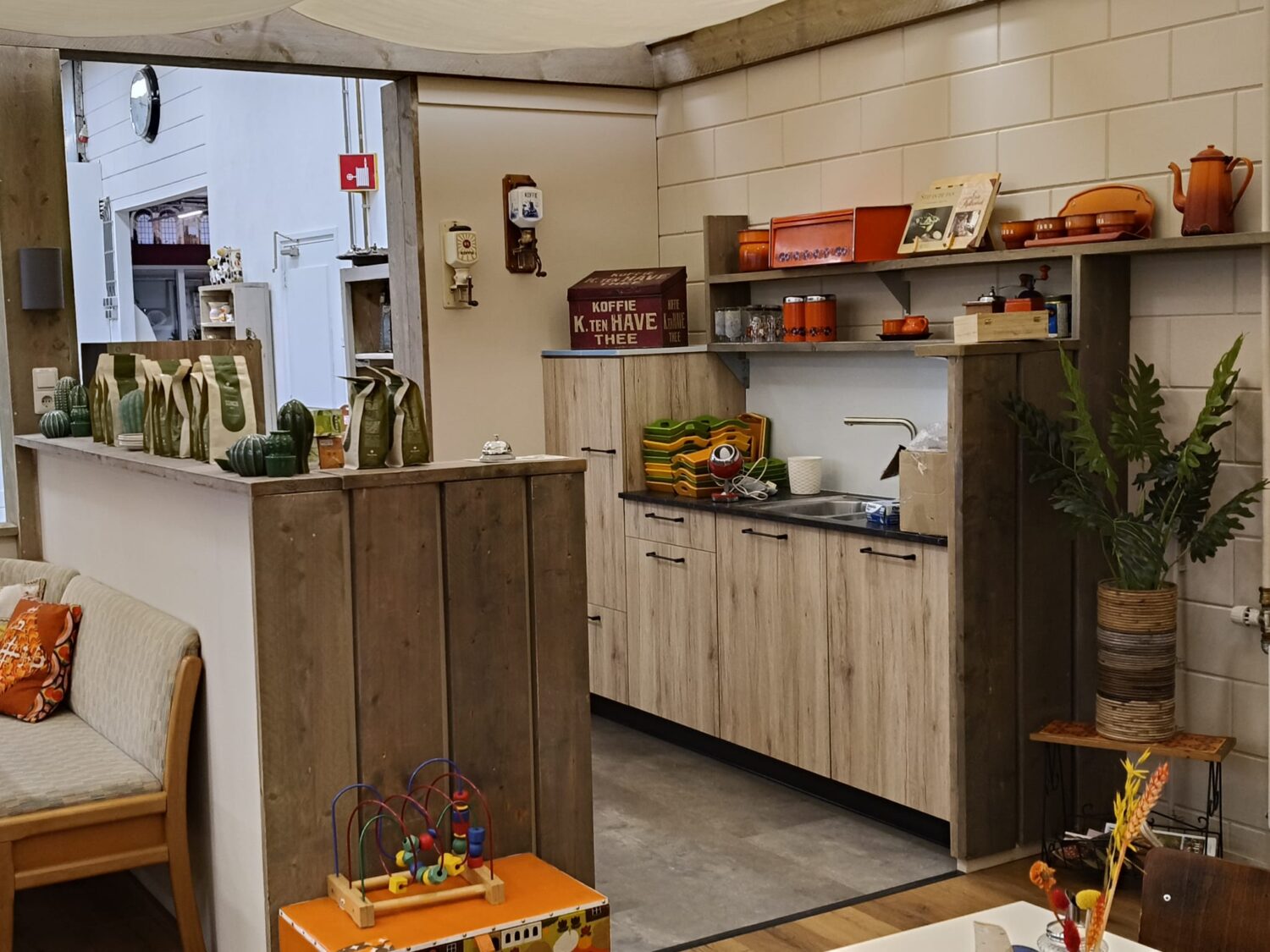 Een gezellige keuken met houten kasten, kleurrijke decoraties en een speelse sfeer, geschikt voor een huis of winkelruimte.