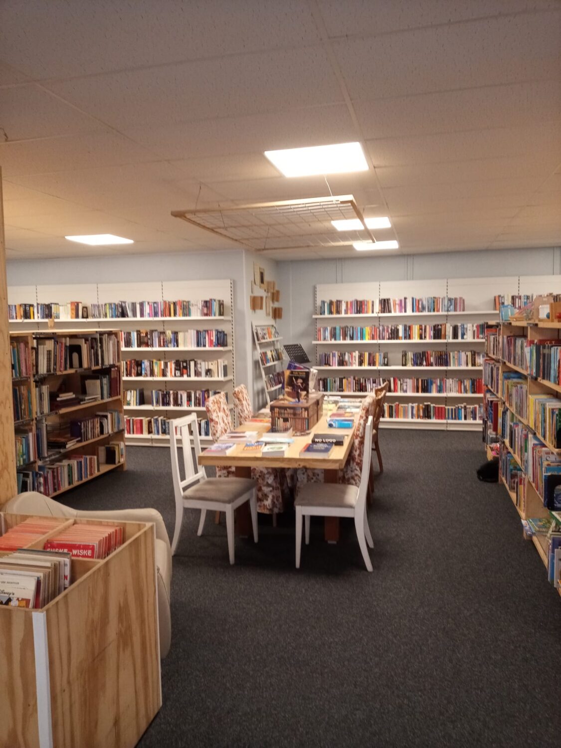 Een gezellige bibliotheek met boekenplanken en een leestafel voor bezoekers om te lezen of te studeren.