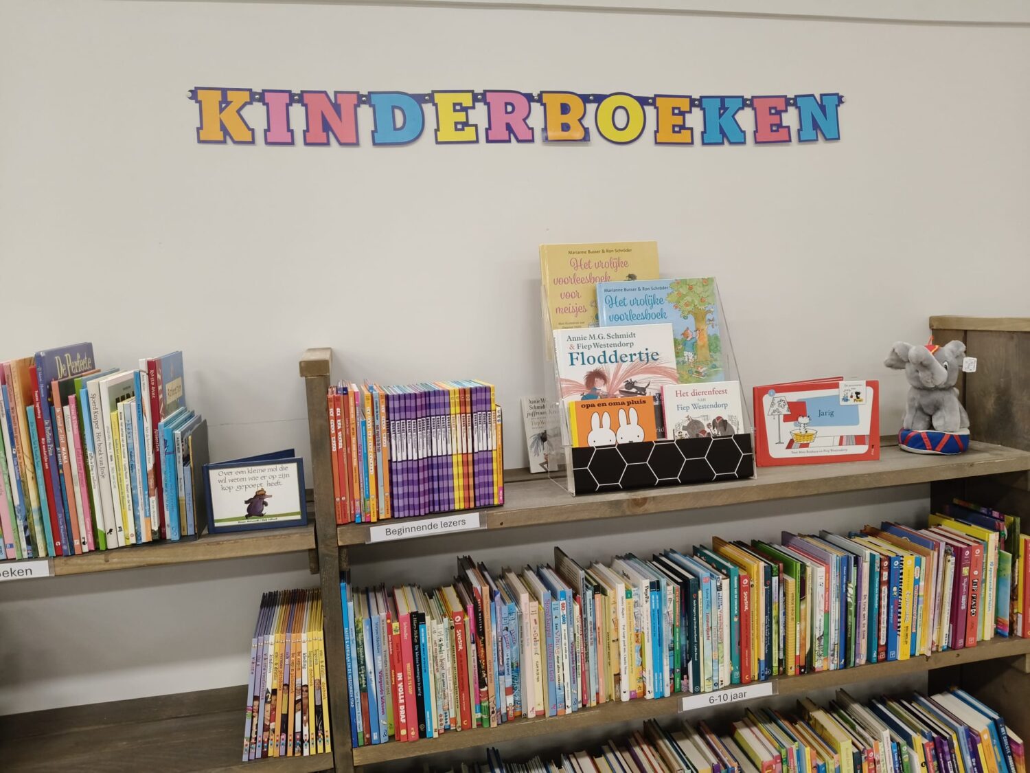 Een kinderboekenplank met een uitgebreide collectie kleurrijke kinderboeken, inclusief prentenboeken en voorleesboeken, geschikt voor jonge kinderen.