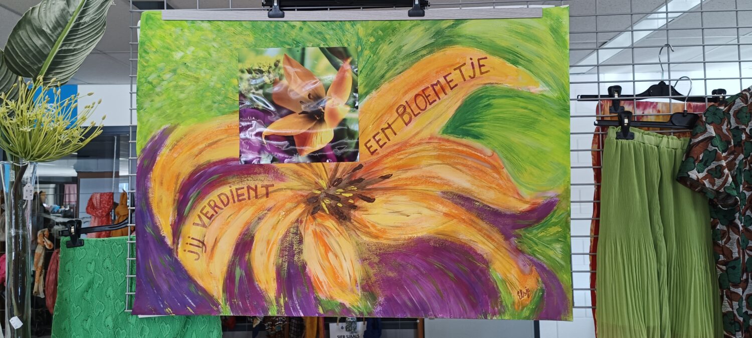 Een kleurrijk bloemstuk met een grote bloem en een groene achtergrond, met de tekst "Jij verdient een bloemetje" in een cirkelvorm.