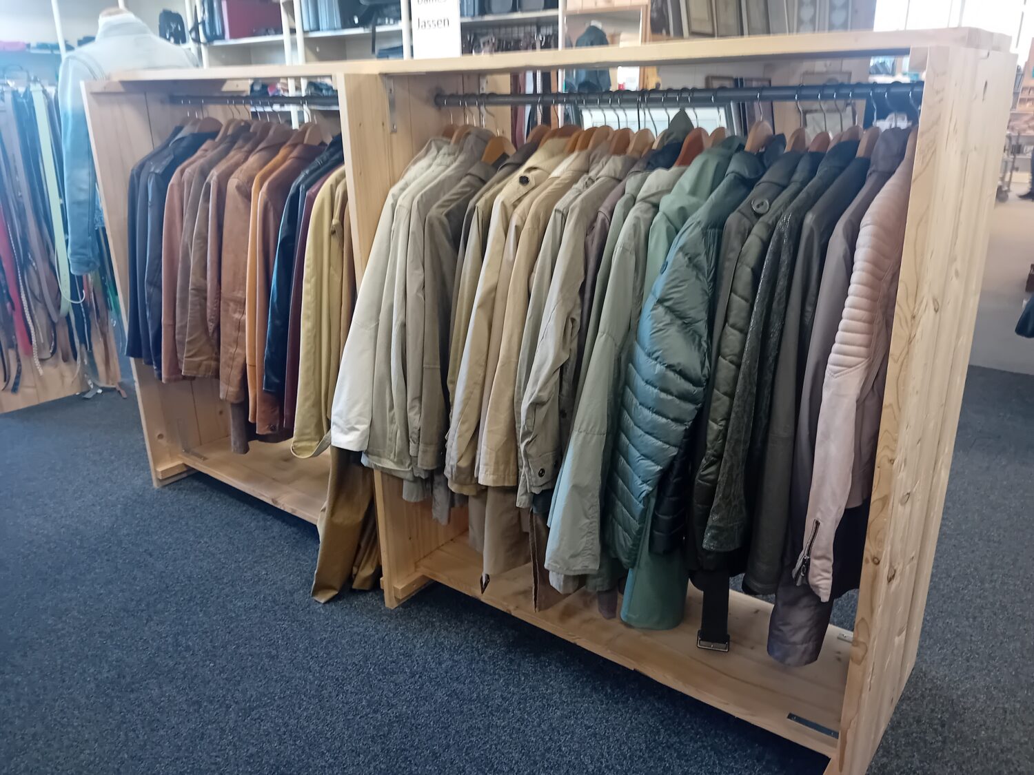 Een kledingrek met een assortiment aan jassen en jacks in verschillende kleuren en stijlen, geschikt voor diverse seizoenen en gelegenheden.