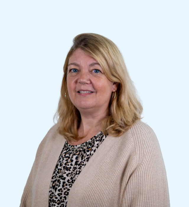 Vrouw met blonde haar en een beige trui, lachend en professioneel, geschikt voor content over fondsen en stichtingen, op de website.