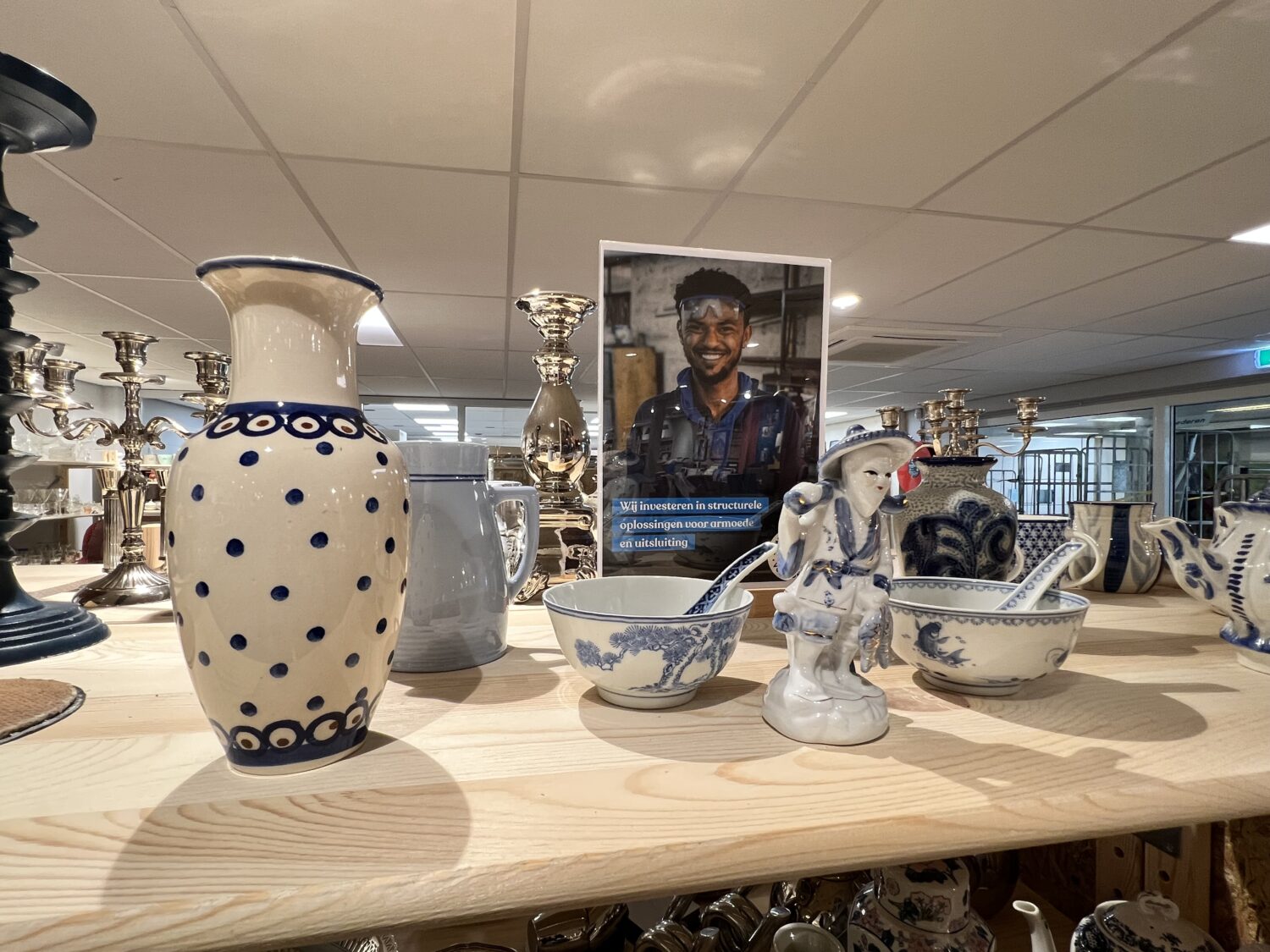 Een collectie van handgemaakte keramiek en beeldjes, inclusief vazen, kommen en decoratieve figuren, uitgestald op een houten tafel.