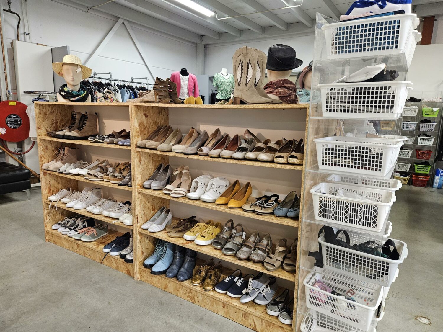 Tweedehands schoenen en accessoires op een houten display in een goed georganiseerde winkel, gericht op armoedebestrijding en humanitaire hulp door Dorcas.