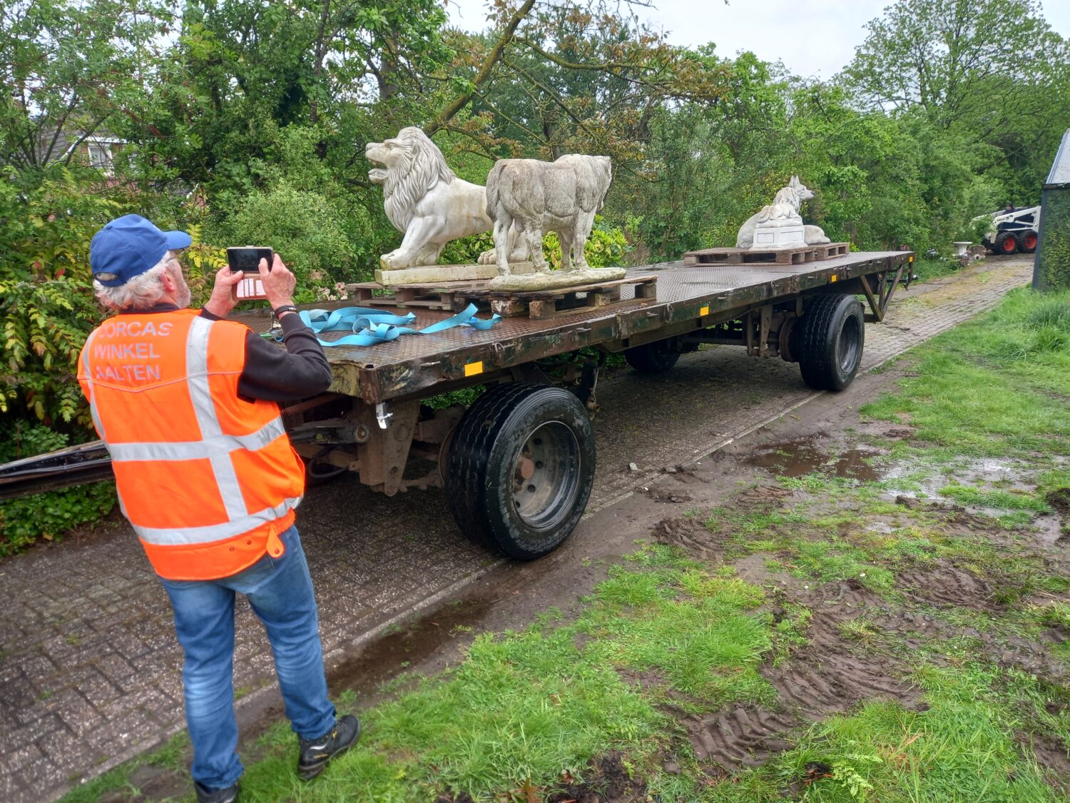 Vrijwilliger fotografeert betonnen dieren op een vrachtwagen voor Dorcas Aalten, symbolisch voor humanitaire hulp en armoedebestrijding in Oost-Europa.