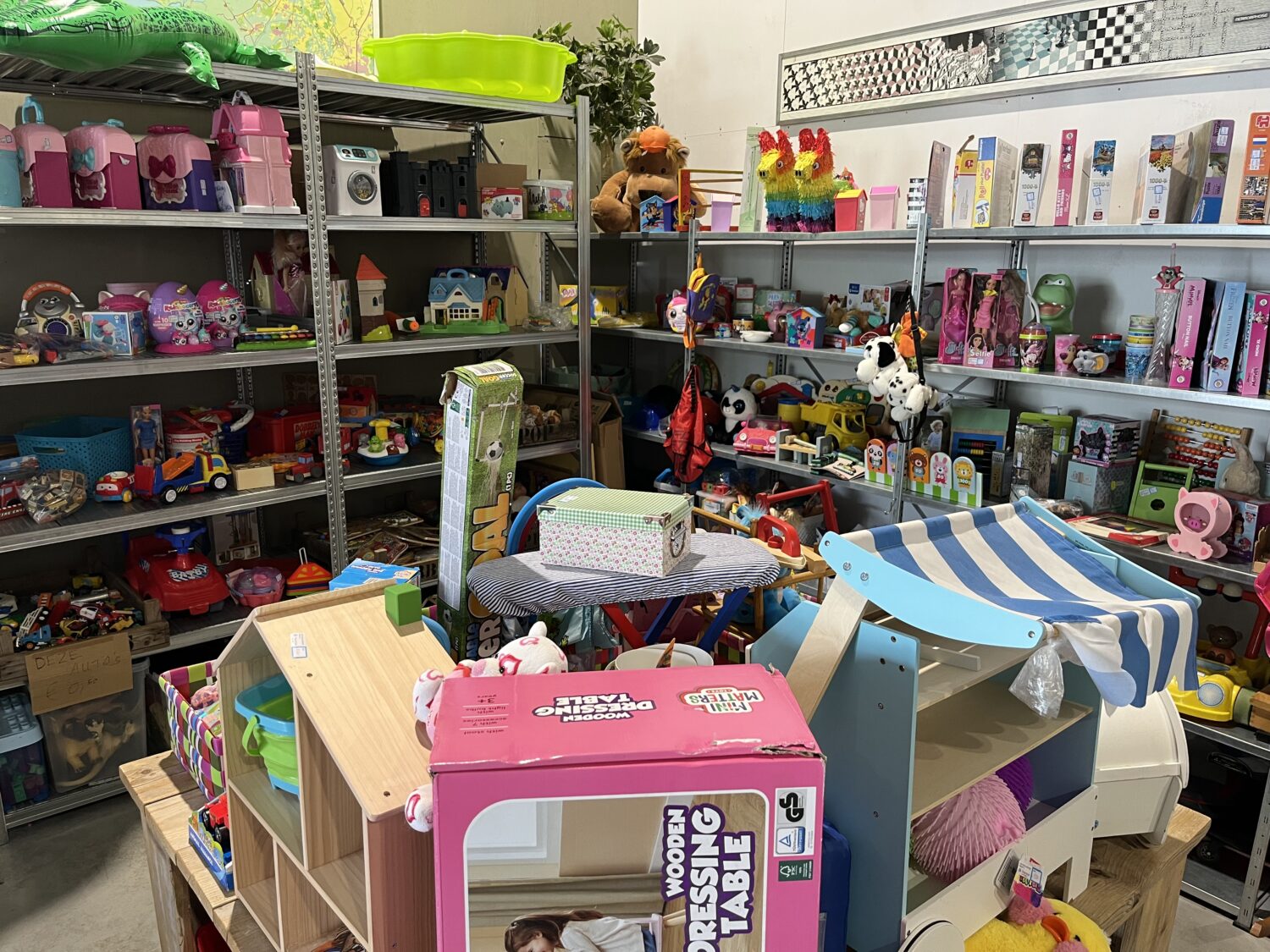 Speelgoedwinkel met diverse kinderartikelen, waaronder poppen, auto's en educatief speelgoed, voor noodhulp en ontwikkelingsprojecten in Oost-Afrika en Oost-Europa.