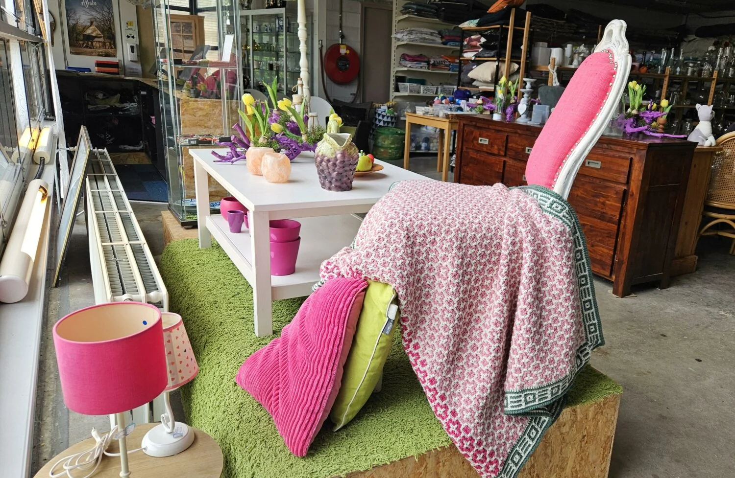 Decoratieve winkelinrichting met kleurrijke accessoires, bloemen en meubels, passend bij de missie van Dorcas voor humanitaire hulp en armoedebestrijding in ontwikkelingslanden.