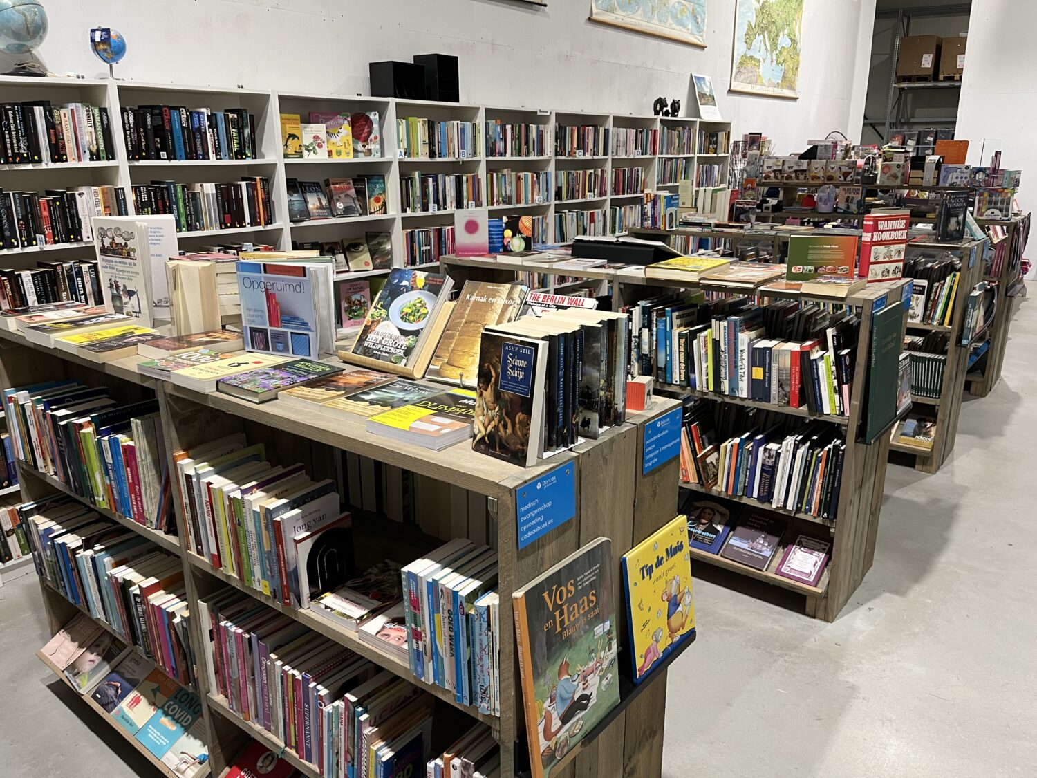 Boekenkast vol met diverse boeken in een bibliotheek, gericht op educatie en kennisdeling, passend bij de missie van Dorcas voor humanitaire hulp en armoedebestrijding.
