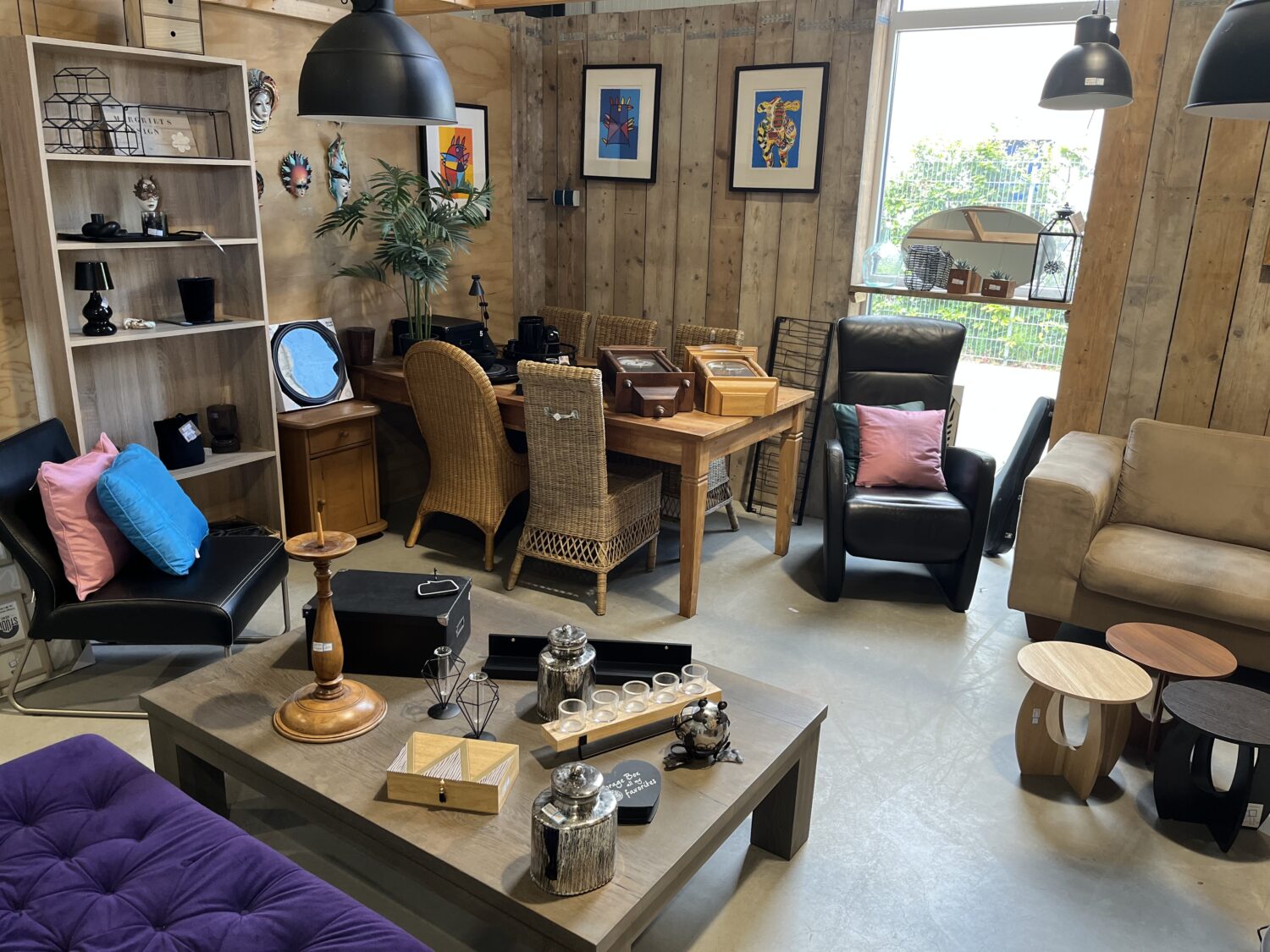 Gezellige woonkamer met houten muren, diverse zitplaatsen, planten en kunst aan de muur, geschikt voor humanitaire hulp en armoedebestrijding.