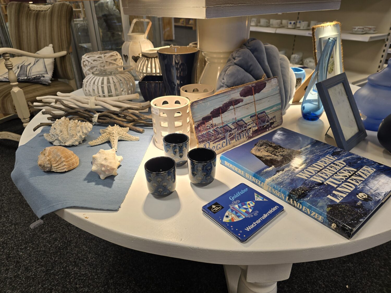 Decoratieve zee-gerelateerde items zoals schelpen, een starfish, en nautische decoraties op een tafel, symboliseren rust en natuur, passend bij humanitaire hulp en armoedebestrijding.