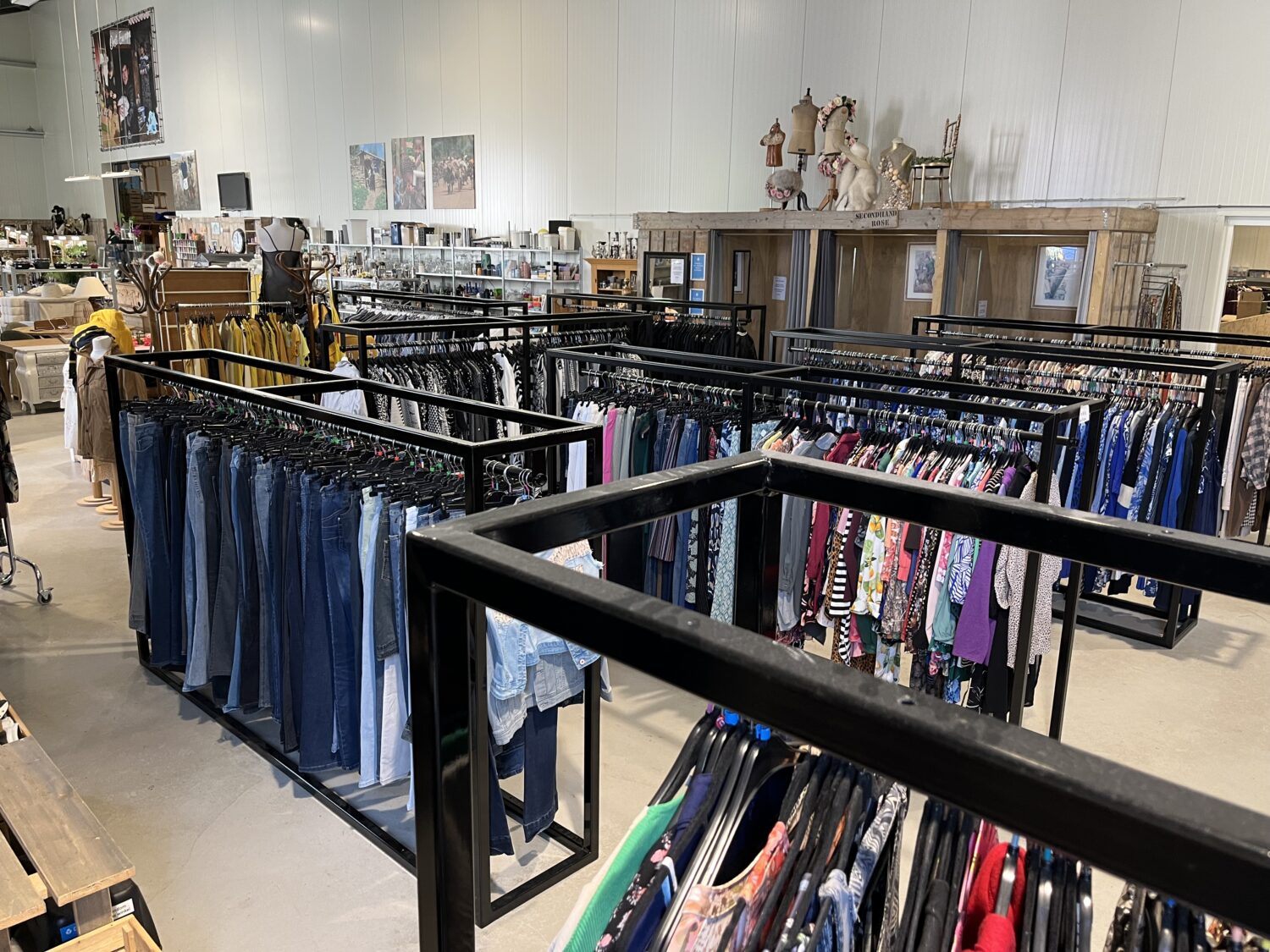 Voedselbank met kledingrekken vol gratis kleding voor mensen in nood, een initiatief voor humanitaire hulp en armoedebestrijding in Nederland.