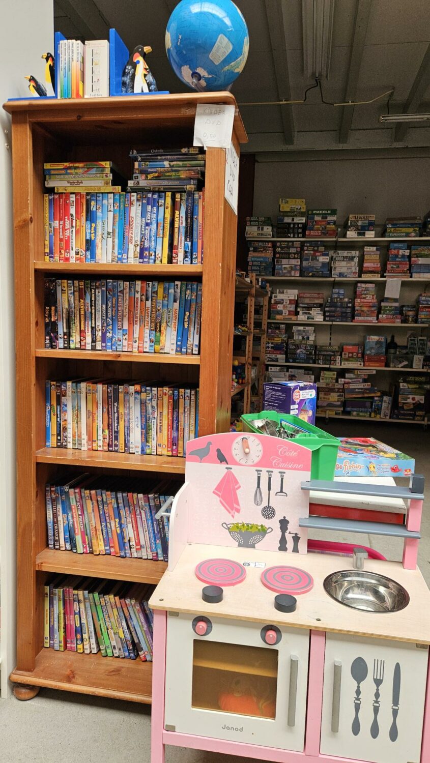 Speelgoedkeuken in een bibliotheek of speelhoek, met boeken en educatief speelgoed, symboliseert educatie en speelse ontwikkeling voor kinderen.