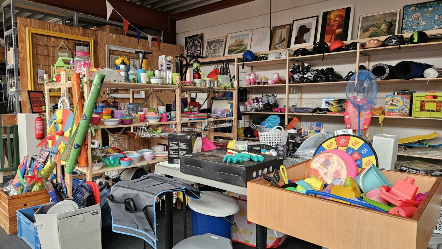Voorraad met speelgoed, schoolmaterialen en huishoudartikelen in een donatiewinkel van Dorcas, gericht op humanitaire hulp en armoedebestrijding in ontwikkelingslanden.