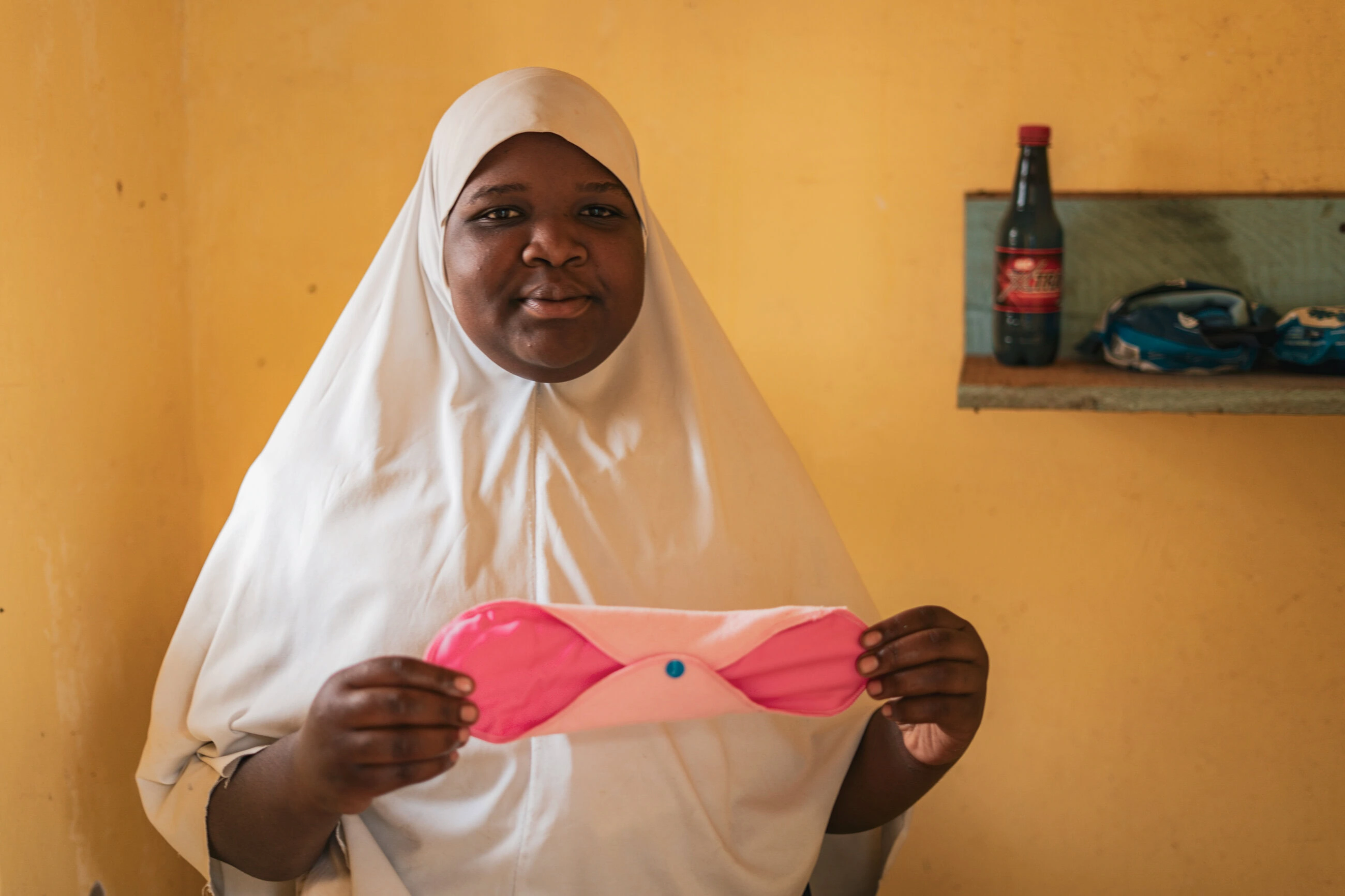 Vrouw in Tanzania toont een menstruatieproduct, een belangrijke stap in het bieden van humitaire hulp en armoedebestrijding voor meisjes en vrouwen in ontwikkelingslanden.