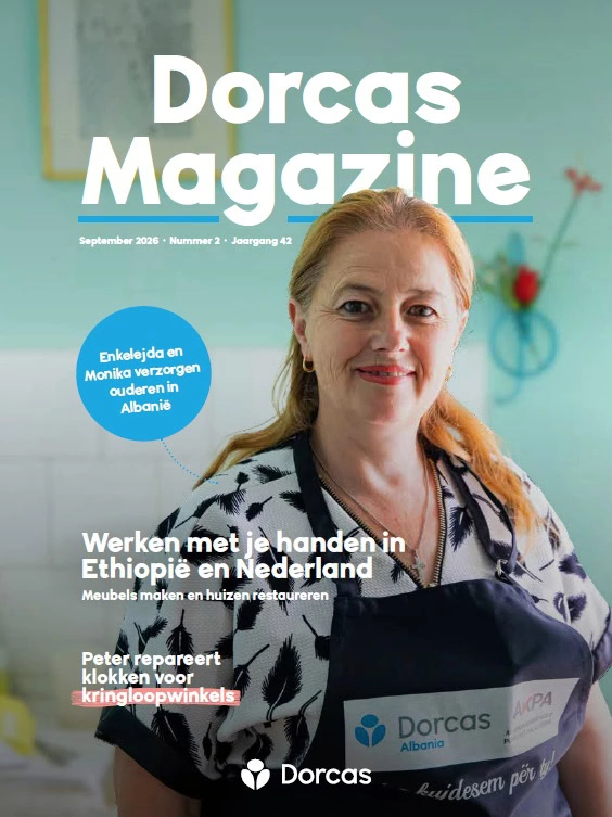 Vrouw op de cover van Dorcas Magazine, september 2026, met een blauwe achtergrond en tekst over humanitaire hulp en armoedebestrijding.