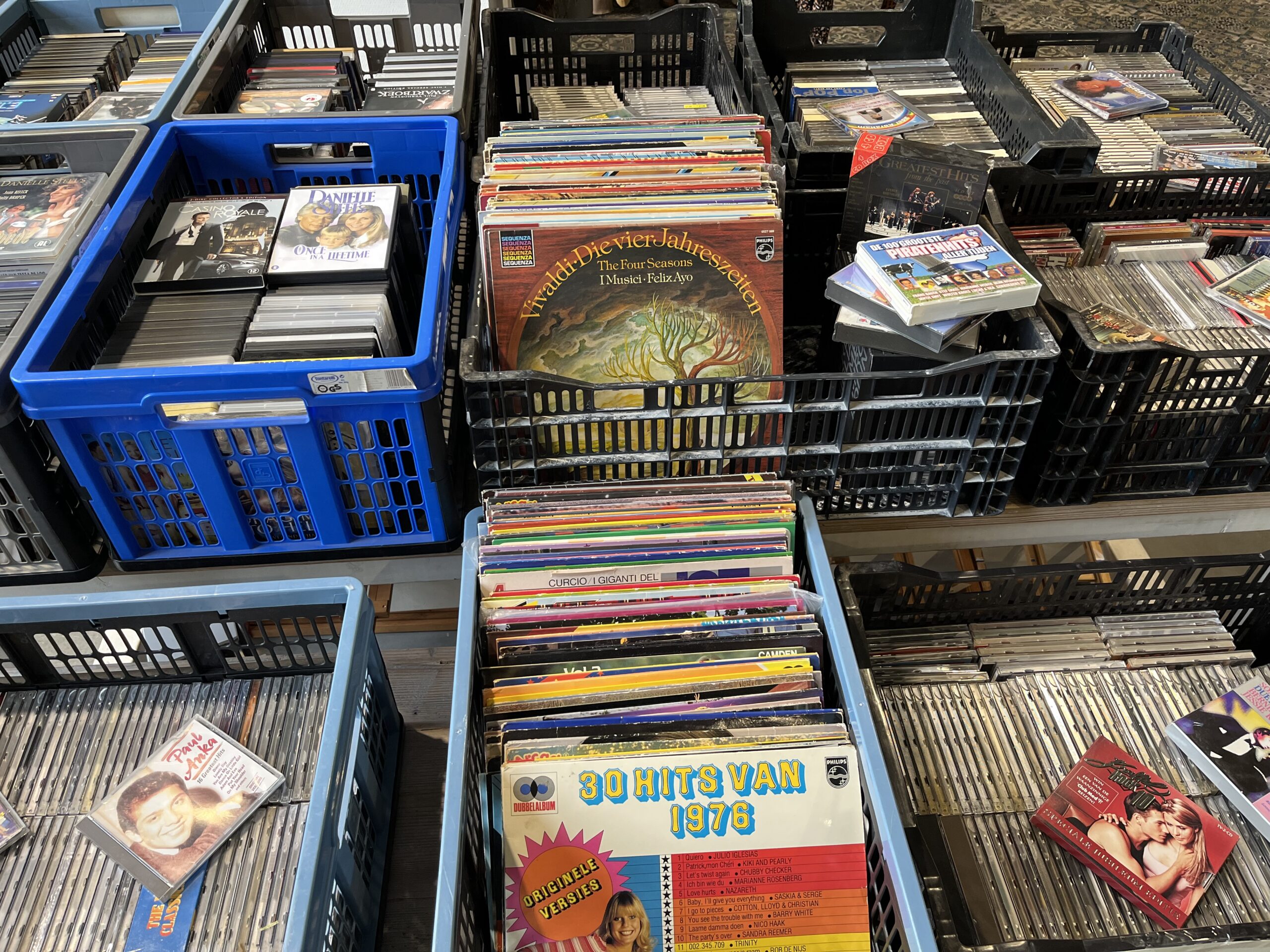 Diverse cd's en vinylplaten in winkelrekken, geschikt voor humanitaire hulp en armoedebestrijding, met focus op educatie en cultuur, passend bij Dorcas' missie.