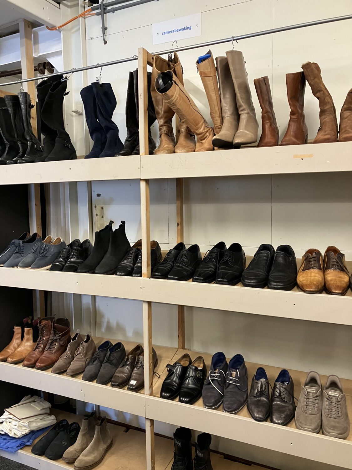 Assortiment schoenen en laarzen op winkelrekken, gericht op humanitaire hulp en armoedebestrijding in Oost-Europa, Oost-Afrika en het Midden-Oosten.