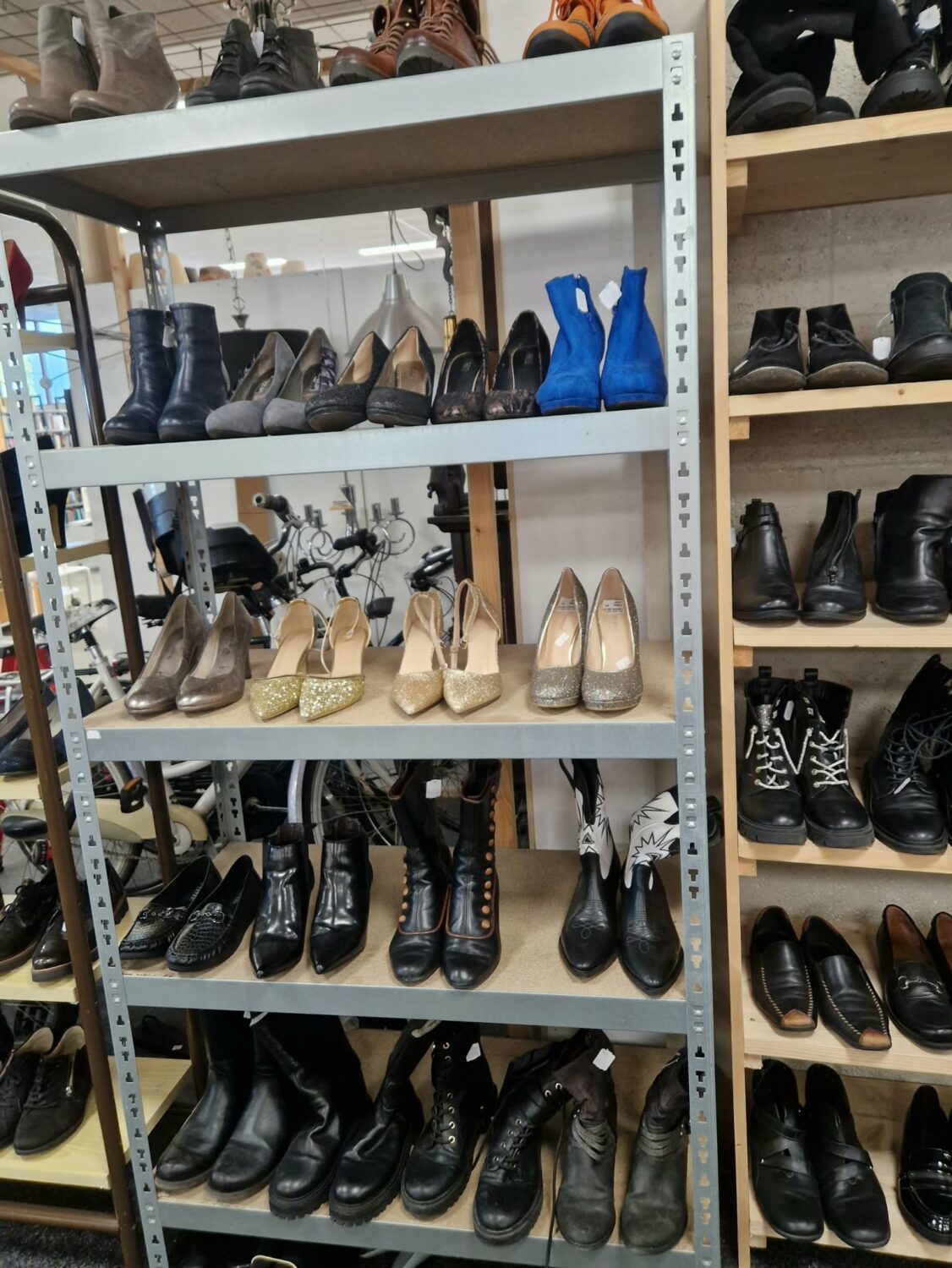 Diverse schoenen op een winkelrek, inclusief hoge hakken, laarzen en sneakers, geschikt voor humanitaire hulp en armoedebestrijding in ontwikkelingslanden.