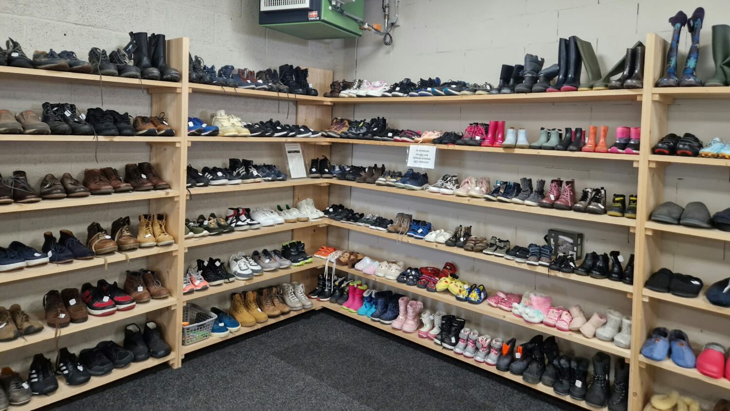 Voorraad schoenen in een winkel, gericht op humanitaire hulp en armoedebestrijding, passend bij de missie van Dorcas.