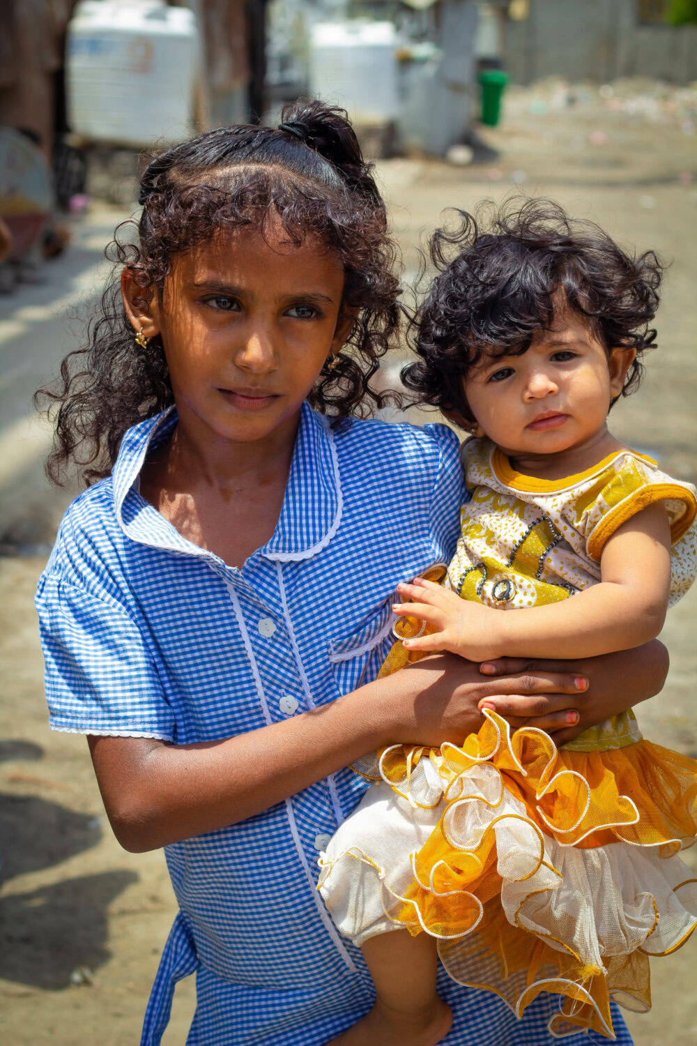Twee jonge meisjes in Jemen, een van hen wordt door de andere vastgehouden, symboliseert de humanitaire hulp en noodhulp voor kinderen in conflictgebieden.