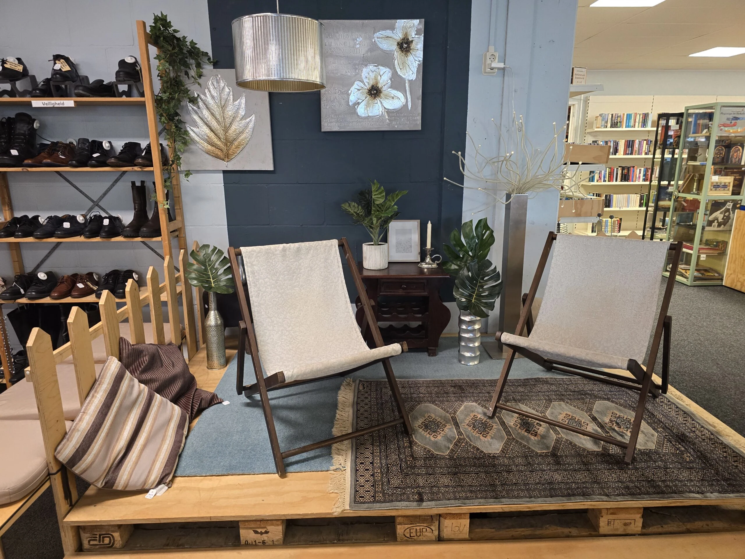 Interieur van een winkel met twee moderne fauteuils, planten, en decoratieve elementen, gericht op comfort en stijl, passend bij humanitaire en ontwikkelingsprojecten.