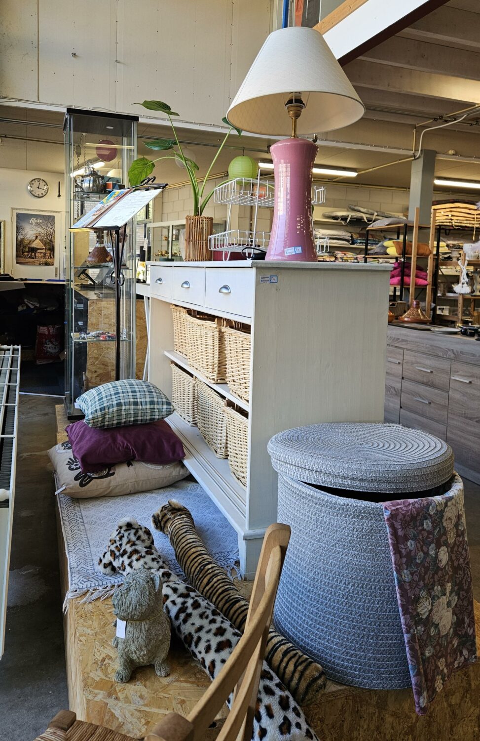 Interieur met vintage meubels, planten, lamp en decoratie, symboliseert hergebruik en duurzaamheid, passend bij de missie van Dorcas voor humanitaire hulp en armoedebestrijding.