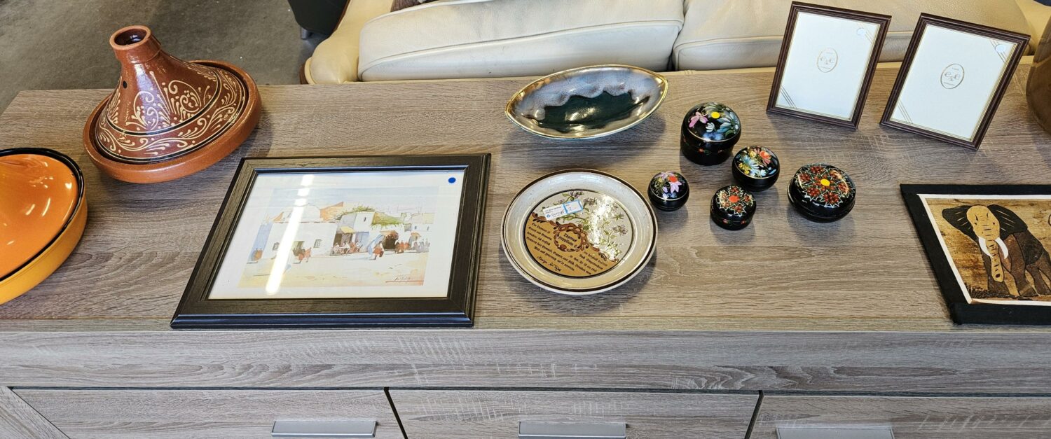 Decoratieve items en kunstwerken op een houten tafel, symbolen van cultuur en creativiteit, passend bij humanitaire en ontwikkelingsprojecten.