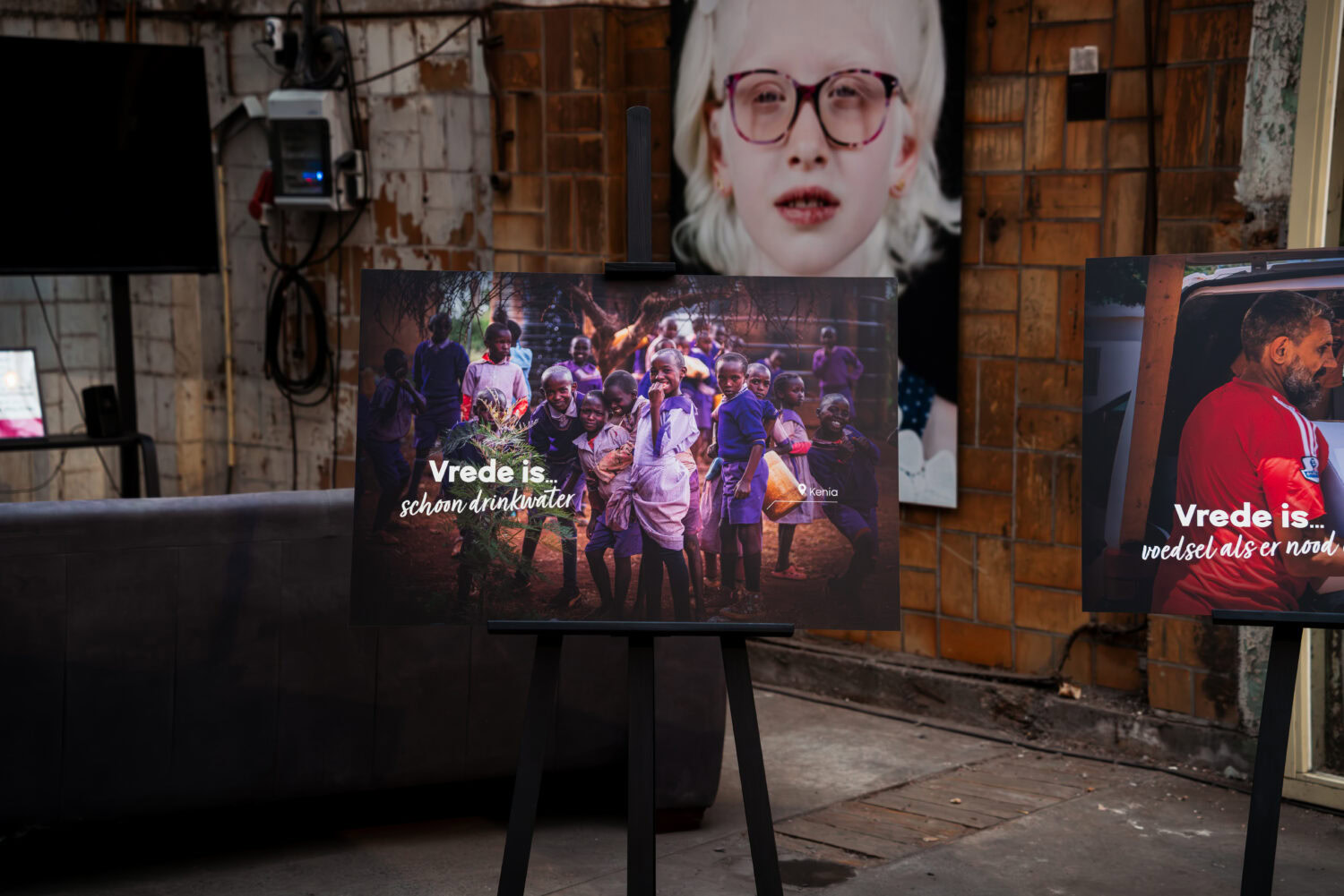 Foto van een tentoonstelling met beelden over vrede en humanitaire hulp, benadrukt de missie van Dorcas voor noodhulp en armoedebestrijding in conflictgebieden.
