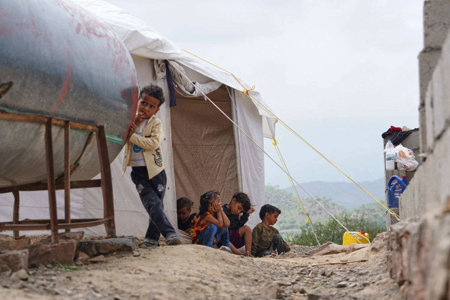 Kinderen in een vluchtelingenkamp in Jemen, wachtend op hulp en ondersteuning, benadrukt de humanitaire crisis en noodhulp voor getroffen gemeenschappen.