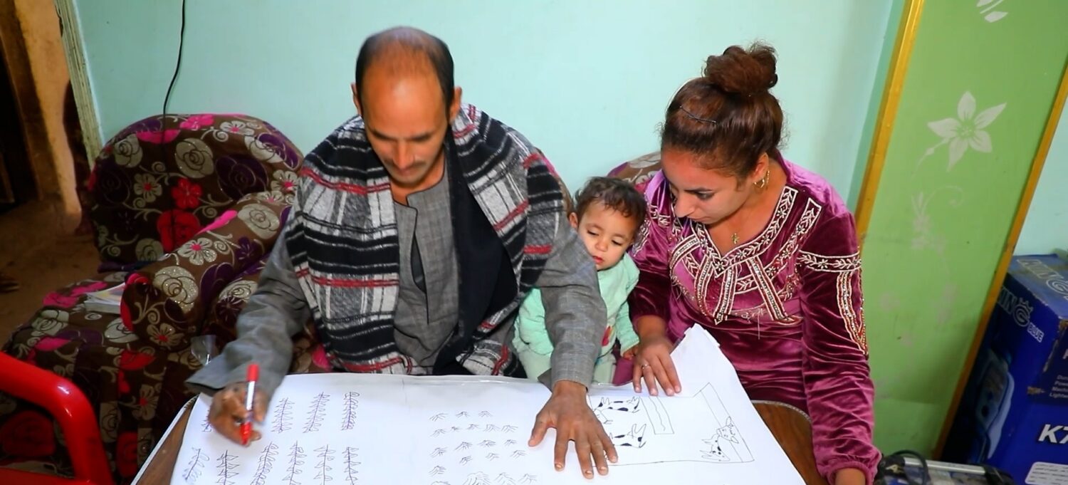 Gezin werkt samen aan kinderen en ouders die leren rekenen met een volwassene aan tafel; illustratie van noodhulp en samenwerking in huiselijke setting voor solidariteit en ontwikkeling.