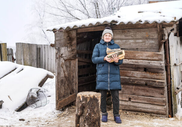 vrouw Tetiana hakt hout in de sneeuw in Oekraine