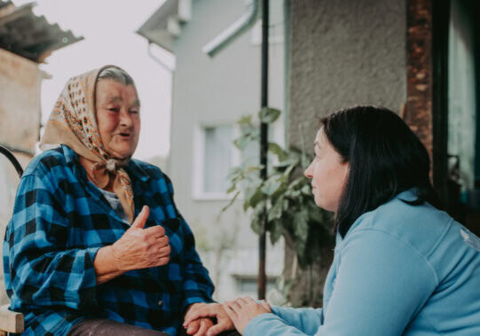 Oudere vrouw en verzorgende in huis, intiem moment, zorgverlening, warmte en aandacht, menselijke connectie, comfort en veiligheid thuis, thuiszorg, mantelzorg, ondersteuning ouderen.