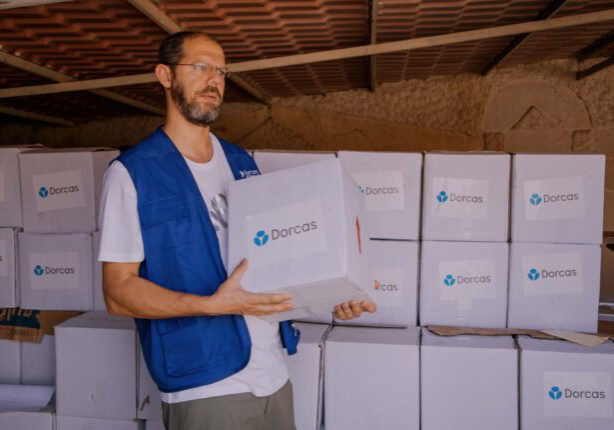 Het CNC, christelijk noodhulpcluster komt in actie met Dorcas als christelijk goed doel actief in landen met grote nood. Op de foto een medewerker die voedsel uitdeelt met een grote witte doos met daarin de benodigheden om te overleven.